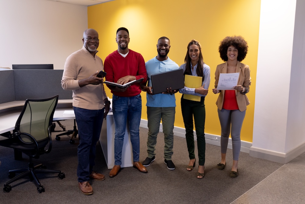 Full length portrait of happy multiracial male and female advisors in modern workplace. unaltered, business, teamwork and modern office concept.