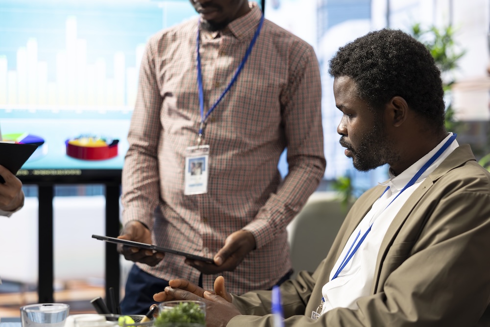 Team of business associates reviewing statistics and infographics on a tablet