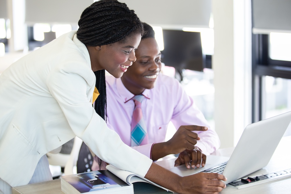 Woman African American leader teaching work analyzing project in company for female employees. Female manager training work for men in corporate. checking work. Teamwork concept.