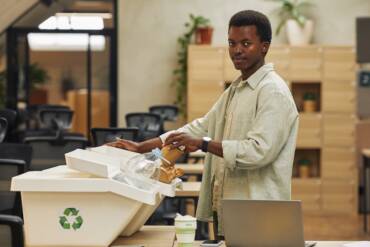 African-American Man Recycling Paper Cup in Office